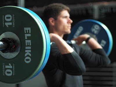 Voimaharjoittelija nostaa painonnostoadetta saliharjossa.