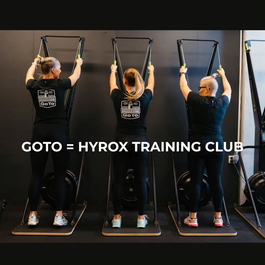 Kolme naista harjoittelee Hyrox-treeneissä Puntit-tilassa, käyttävät vastuskuminauhoja ja harjoitusv.