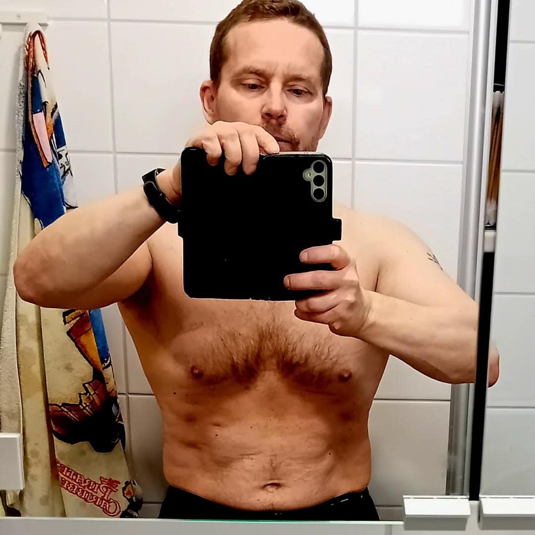 Selfie miehestä peilissä, paljain yläkroppana.
