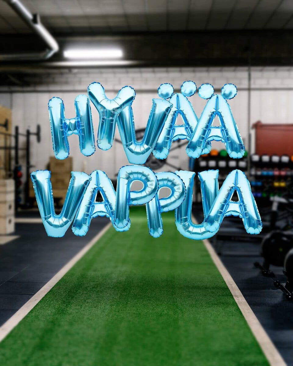 HUMAAVAPPUA ilmapallot, jotka muodostavat "HUMAA VAPPUA" tekstin liikuntakeskuksen salissa.