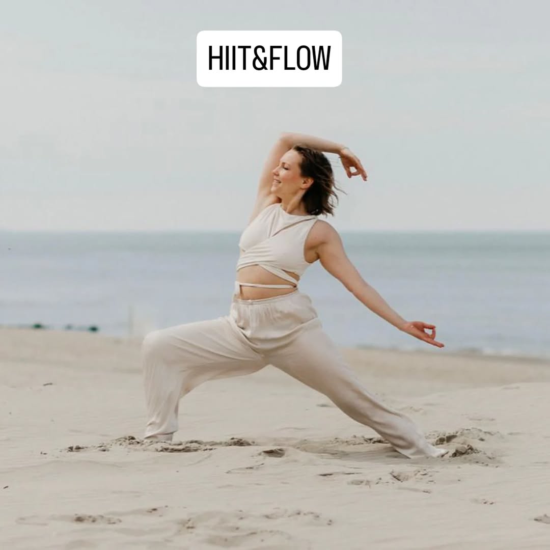 Nainen harjoittelee HIIT & Flow joogaa rannalla, merimaisema taustalla.