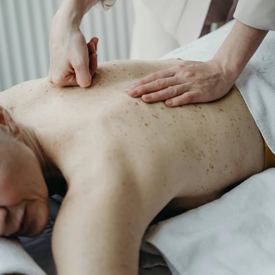 Lääketieteellinen hoitaja suorittaa hoitotoimenpiteen potilaan selälle.