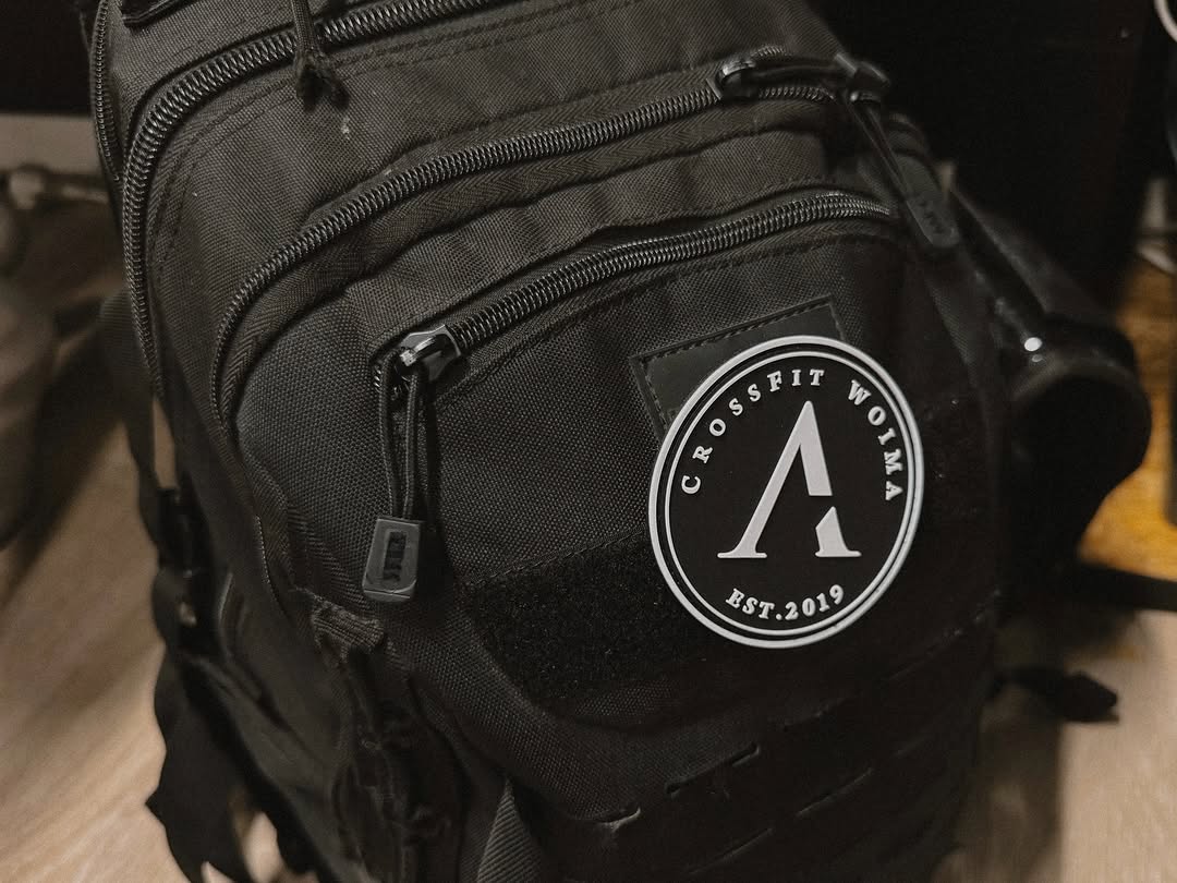 Musta Crossfit-reppu, jossa logo ja useita taskuja, sopii urheiluun ja treeneihin.
