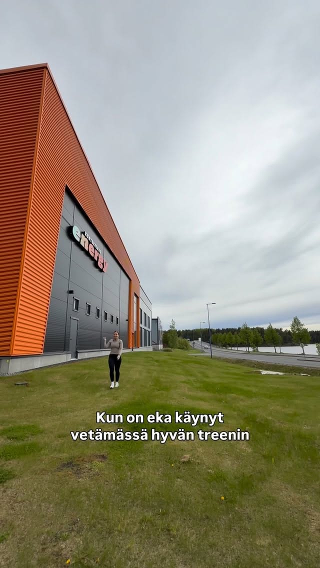 Modern Puntit gym rakennus ulkoa, vihreä nurmikko ja pilvinen taivas.