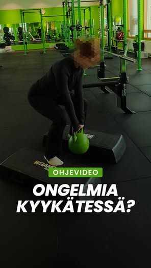 Nainen nostaa painonnostotankoa kuntosalilla, vihreä väriteema.