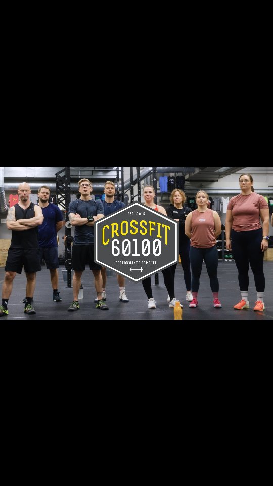 Ryhmän jäsenet Crossfit-salilla poseeraavat etualalla.